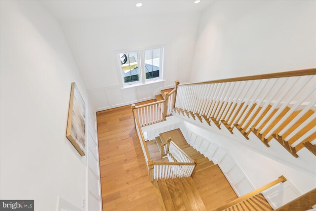 stairs featuring hardwood / wood-style flooring and recessed lighting