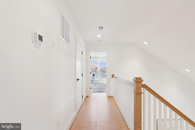 hallway with an upstairs landing, visible vents, recessed lighting, and light wood-type flooring