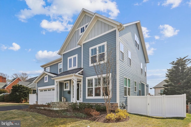 view of front of house featuring a standing seam roof, fence, board and batten siding, metal roof, and a garage