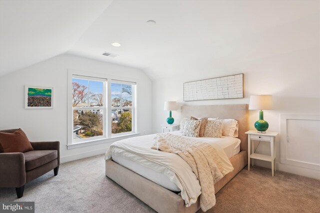 bedroom featuring visible vents, lofted ceiling, and carpet flooring