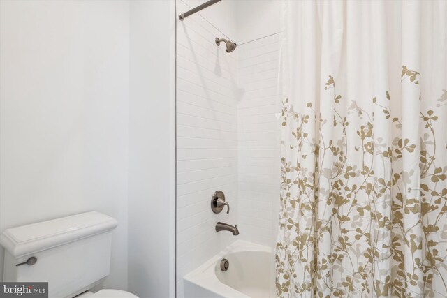 full bathroom with toilet and shower / bath combo with shower curtain