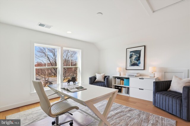 office space featuring light wood-style floors, visible vents, and baseboards