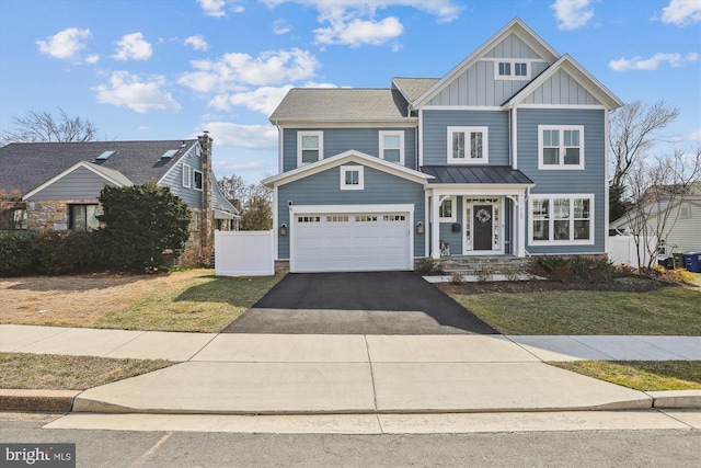 view of front of home with fence, a standing seam roof, a garage, aphalt driveway, and board and batten siding