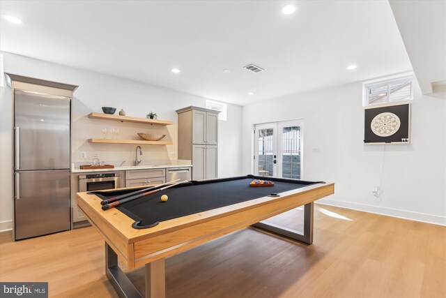 rec room with visible vents, light wood-type flooring, indoor wet bar, recessed lighting, and french doors