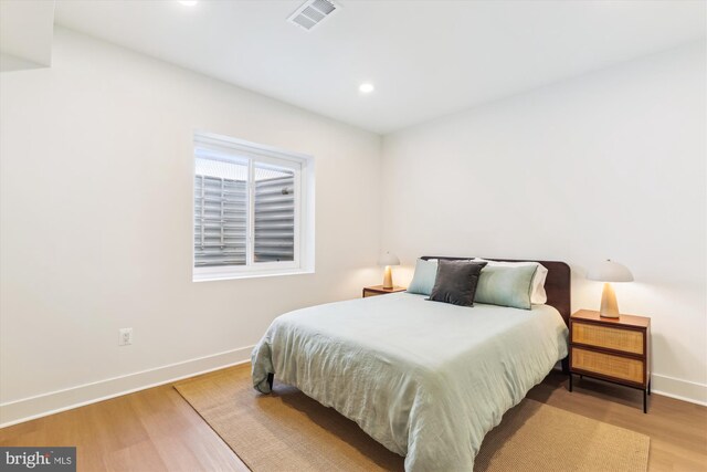 bedroom with recessed lighting, visible vents, baseboards, and wood finished floors