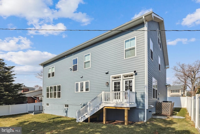 rear view of house featuring a deck, a lawn, a fenced backyard, and stairs