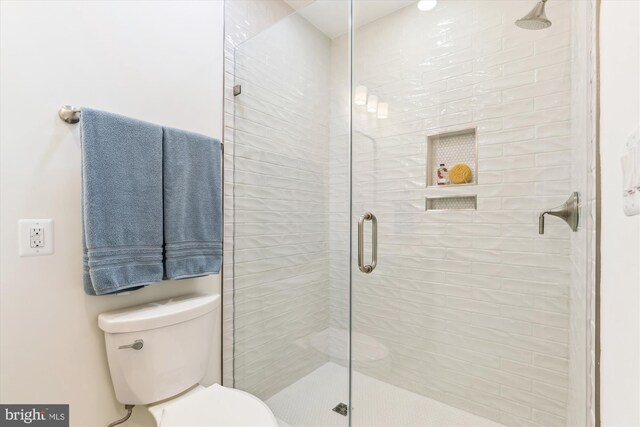 bathroom with toilet and a stall shower