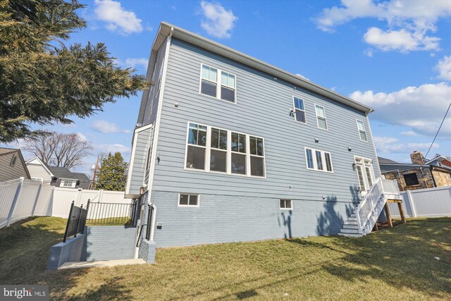 back of property featuring a yard and a fenced backyard