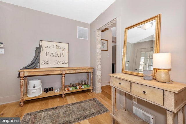 interior space with visible vents, baseboards, and wood finished floors