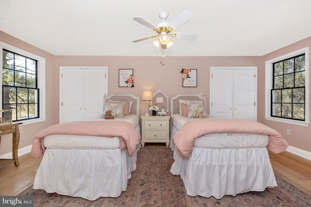 bedroom featuring multiple windows, wood finished floors, and baseboards