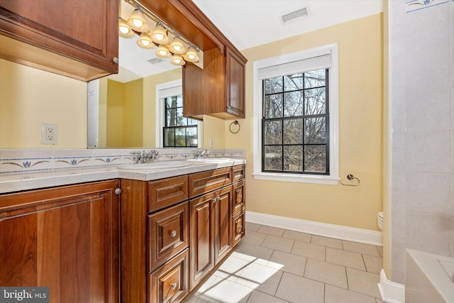 bathroom featuring a tub to relax in, tile patterned flooring, a sink, visible vents, and double vanity