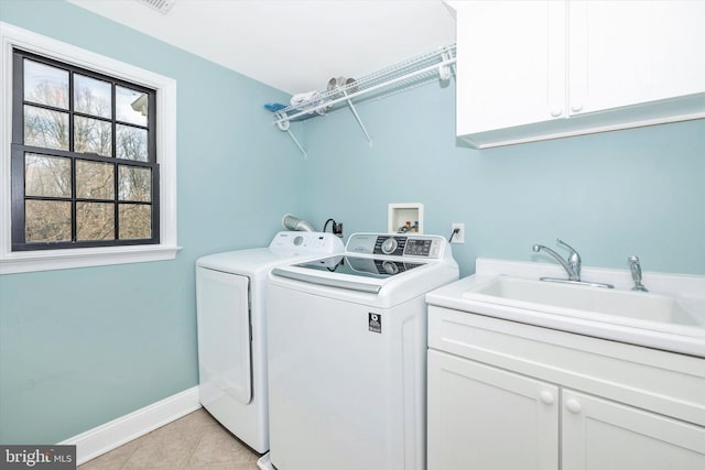 laundry area with washer and clothes dryer, light tile patterned floors, cabinet space, a sink, and baseboards