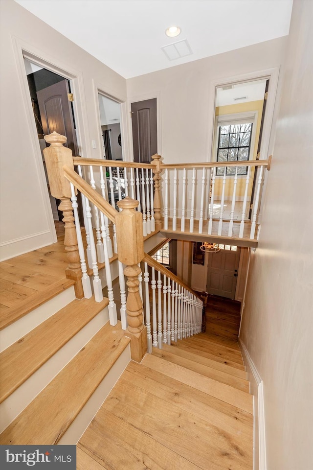 stairs featuring visible vents, wood finished floors, and recessed lighting