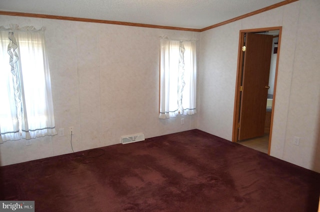 empty room featuring ornamental molding, carpet flooring, and visible vents