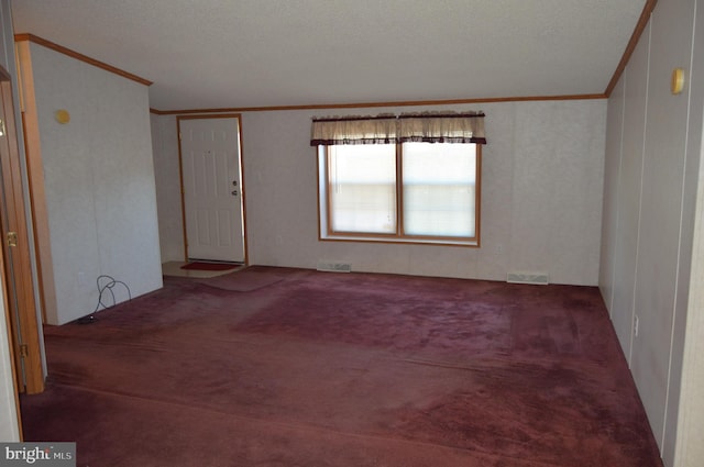 carpeted empty room featuring ornamental molding and visible vents