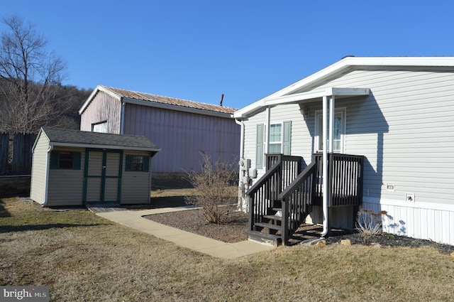 view of side of property featuring an outbuilding, a lawn, and a shed