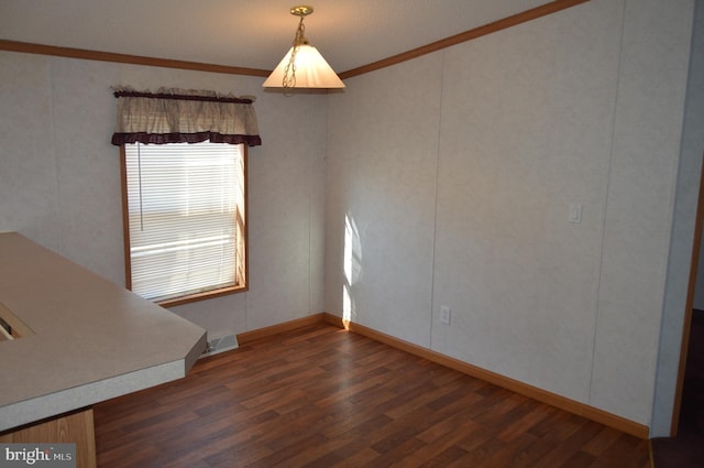 unfurnished room featuring crown molding, baseboards, and wood finished floors