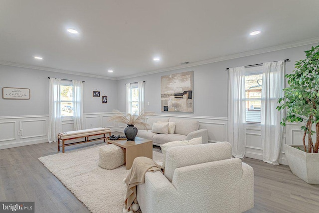 living area with recessed lighting, light wood-type flooring, and crown molding