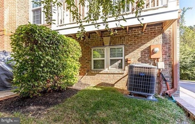 exterior space featuring central AC unit and brick siding