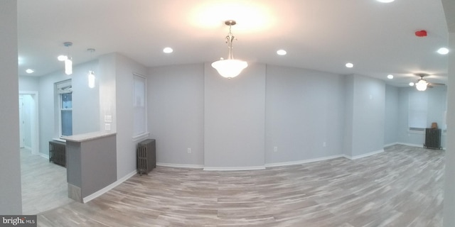 interior space featuring recessed lighting, baseboards, light wood finished floors, and radiator heating unit