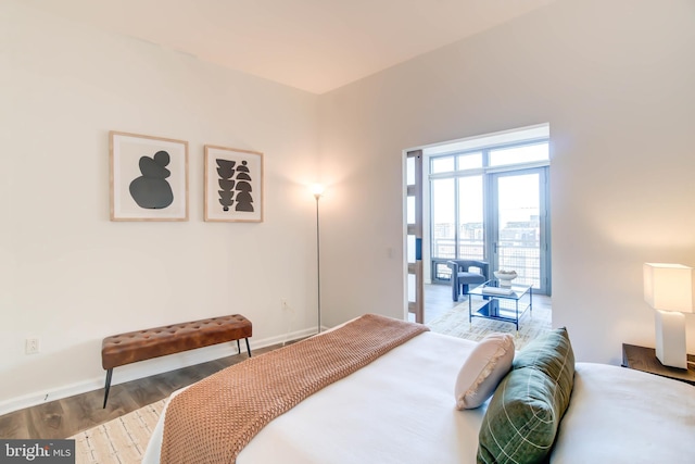 bedroom with baseboards and wood finished floors