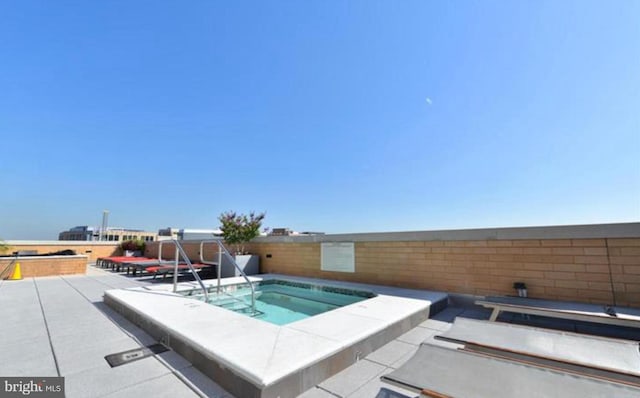 view of pool featuring a patio area and an in ground hot tub