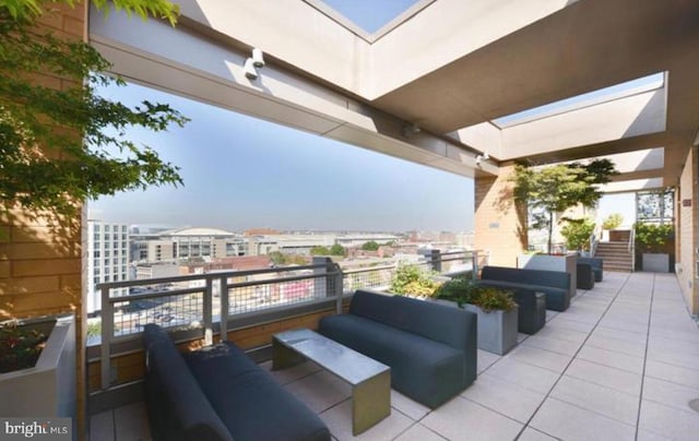 view of patio with a balcony, a view of city, and outdoor lounge area