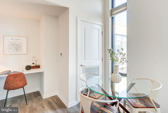 dining space featuring wood finished floors and baseboards