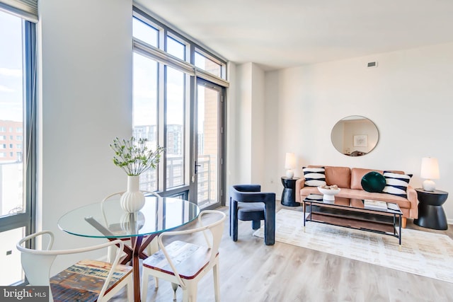 interior space featuring light wood-type flooring and a wall of windows