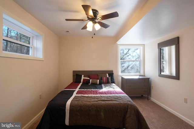 carpeted bedroom featuring ceiling fan, visible vents, and baseboards