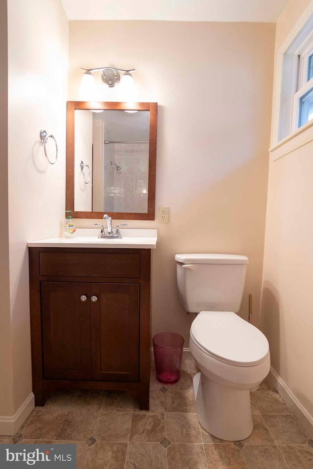 bathroom with toilet, baseboards, and vanity