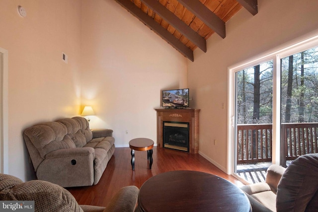 living area with high vaulted ceiling, wooden ceiling, a fireplace, wood finished floors, and beam ceiling