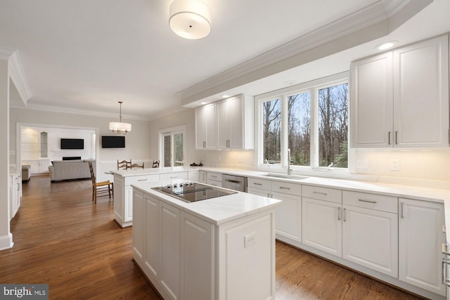 kitchen with wood finished floors, black electric stovetop, crown molding, white cabinetry, and a sink