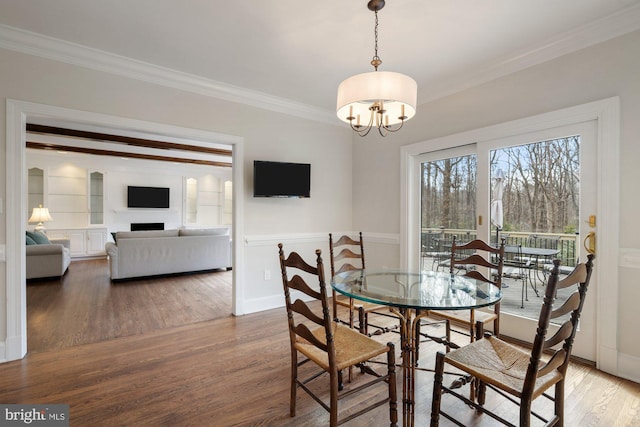 dining area featuring a notable chandelier, crown molding, baseboards, and wood finished floors