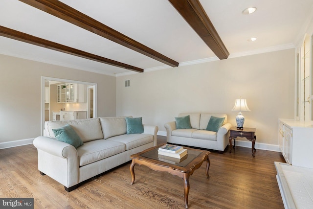 living area featuring crown molding, baseboards, beam ceiling, and wood finished floors