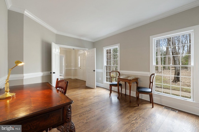 office with baseboards, crown molding, visible vents, and wood finished floors