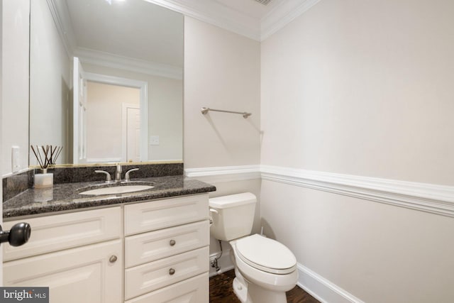 half bathroom with crown molding, vanity, toilet, and wood finished floors