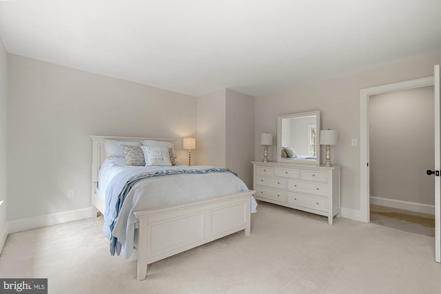 bedroom featuring light colored carpet and baseboards