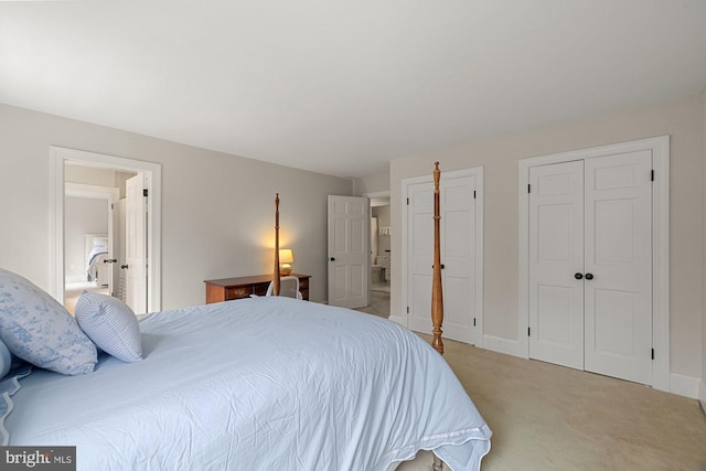 bedroom featuring multiple closets, light carpet, ensuite bath, and baseboards