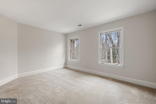 spare room with light carpet, baseboards, and visible vents