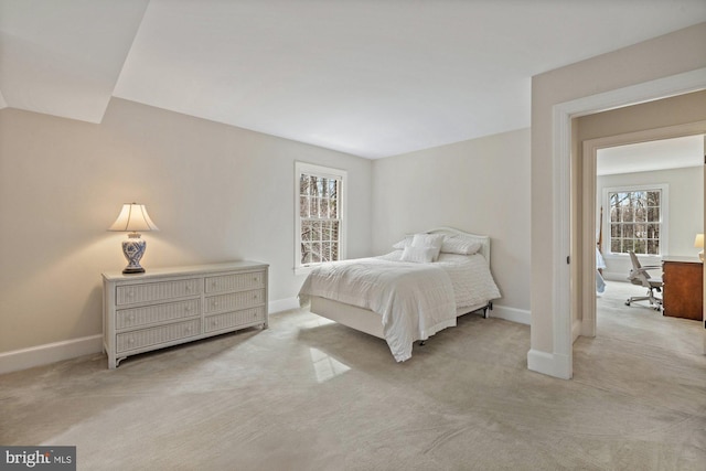 bedroom with light carpet and baseboards