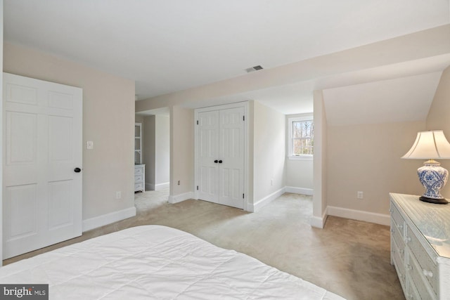 bedroom featuring lofted ceiling, a closet, visible vents, light carpet, and baseboards