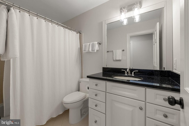 bathroom with tile patterned flooring, curtained shower, vanity, and toilet