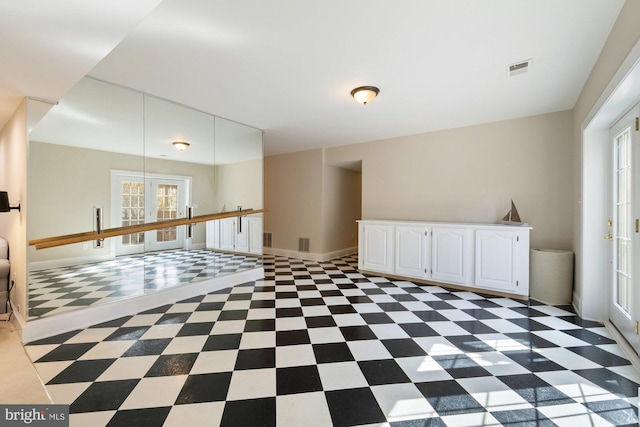 empty room with french doors, visible vents, baseboards, and tile patterned floors