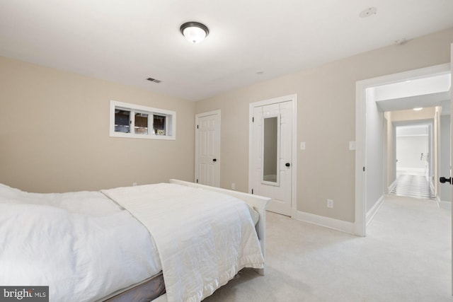 bedroom featuring light carpet, visible vents, and baseboards