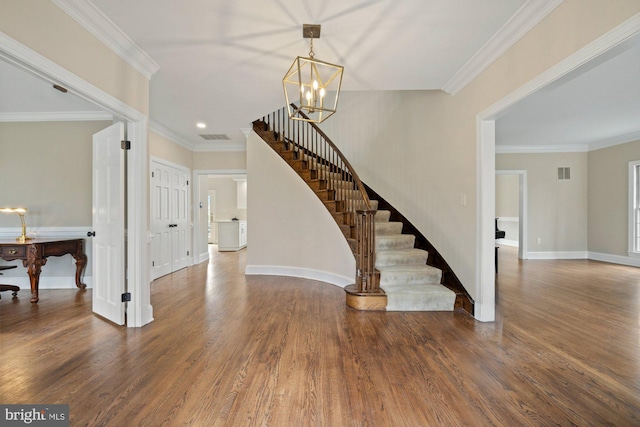 foyer featuring visible vents, crown molding, stairway, and wood finished floors