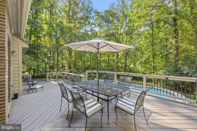 wooden terrace with a fenced in pool and outdoor dining space