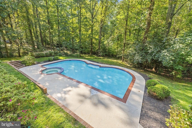 view of pool with a pool with connected hot tub, a lawn, and a wooded view