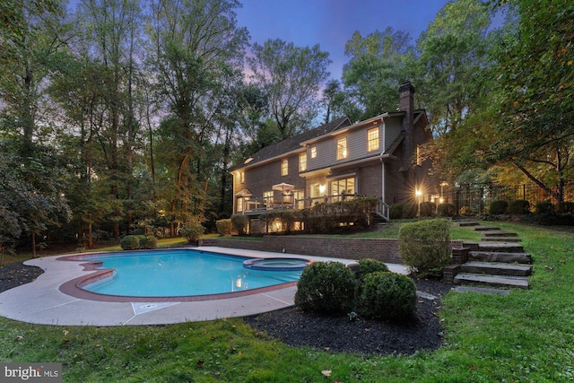 view of swimming pool featuring a pool with connected hot tub, stairway, and a deck