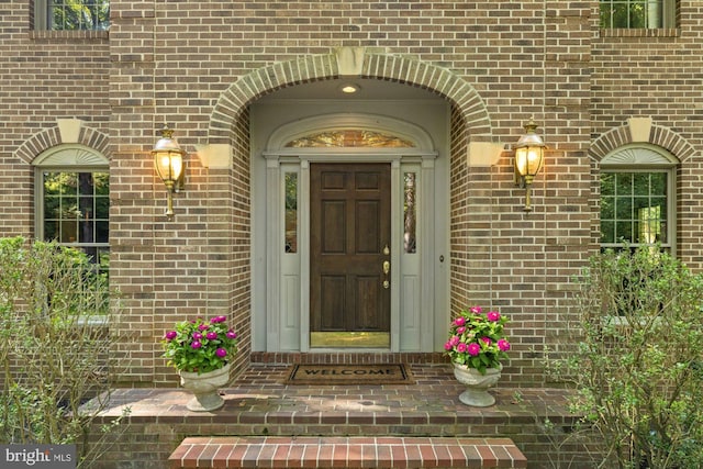 view of exterior entry featuring brick siding